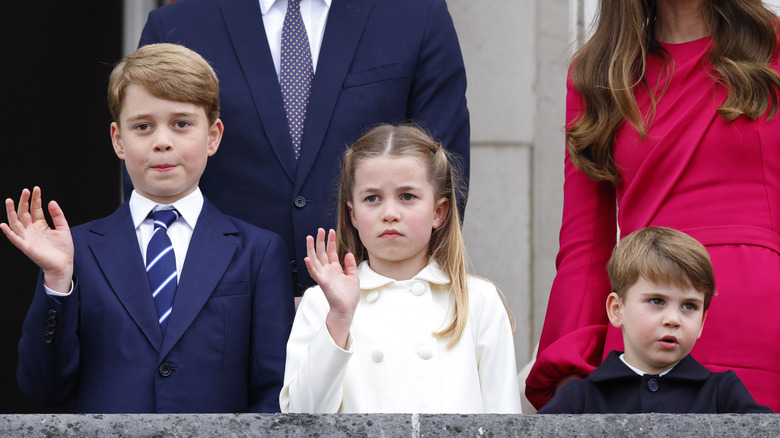 Prine George, Princess Charlotte, and Prince Louis waving and frowning