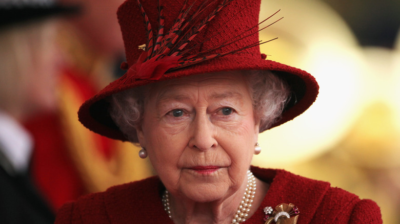 Queen Elizabeth wearing a red hat