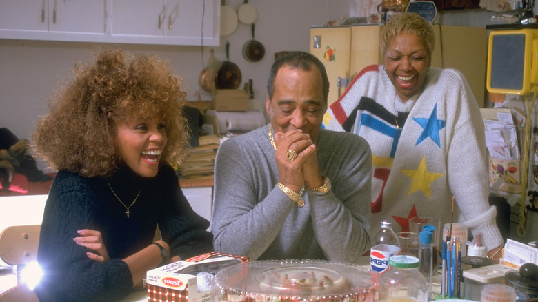 Whitney Houston at a table with her parents