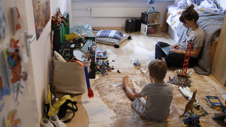 Woman working from home with a child playing