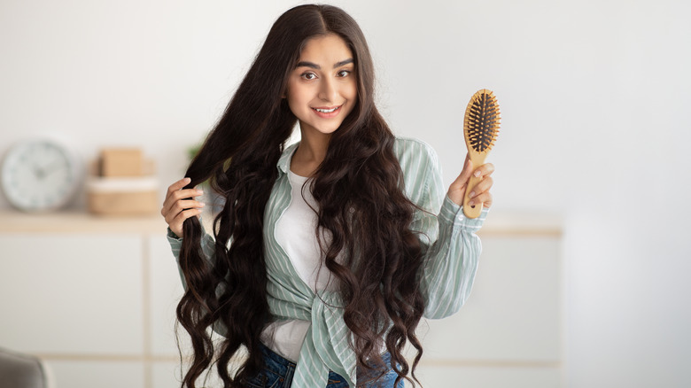 A woman with long hair holding hairbrush