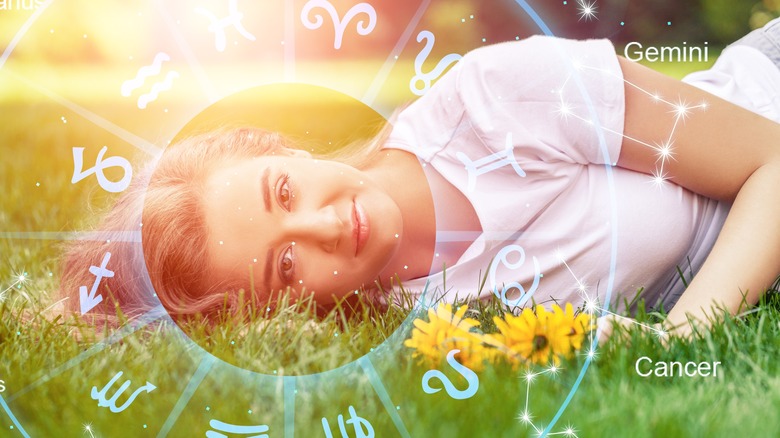 Woman lying on grass with astrology signs