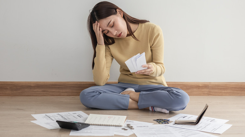 Woman looks frustrated as she pays her bills