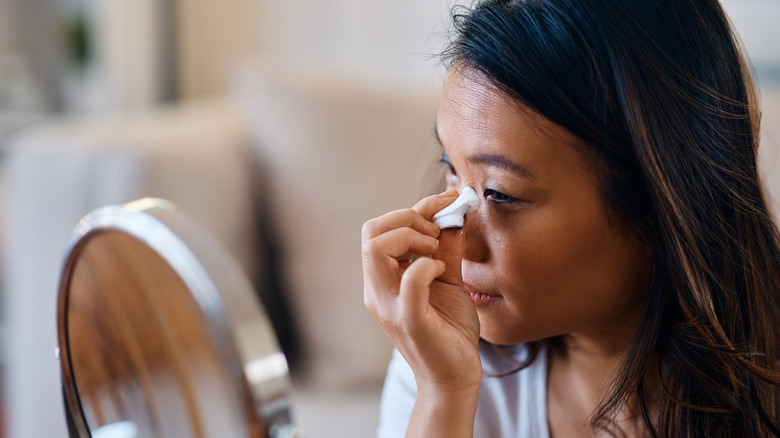 Woman wiping off eye makeup