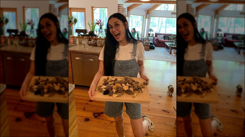 Demi Moore smiling and holding a cutting board