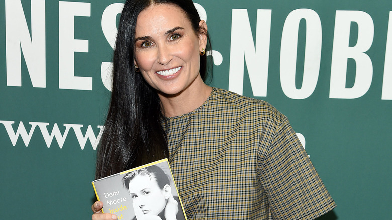 Demi Moore holding her memoir