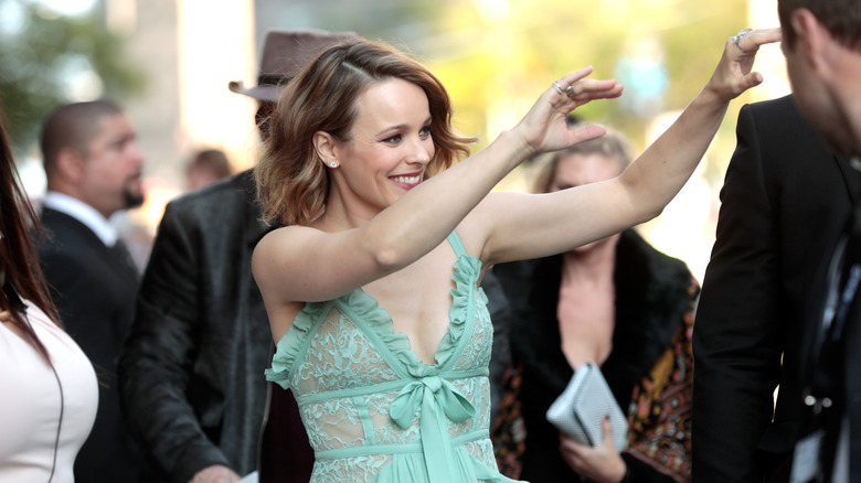 Rachel McAdams waving in a green lace outfit 