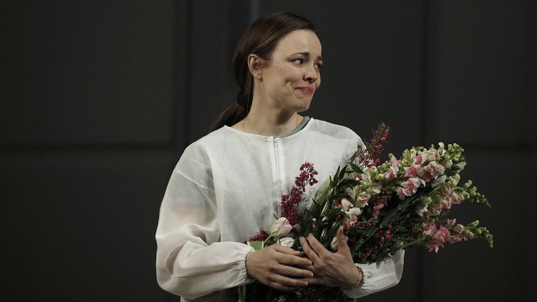 Rachel McAdams teary-eyed holding a bouquet 