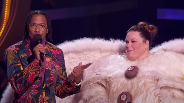 Nick Cannon and Chrissy Metz on The Masked Singer stage, with Metz in a Poodle Moth costume