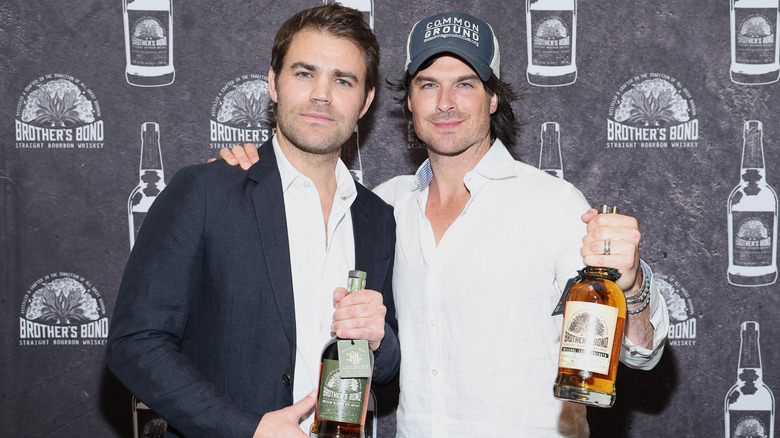 Paul Wesley and Ian Somerhalder posing together with their bourbon 