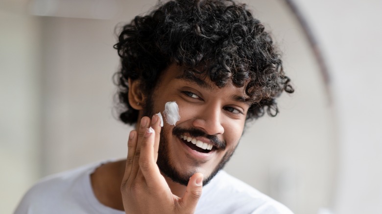 Man applying moisterizer