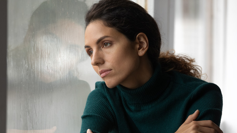 Woman looks out window 