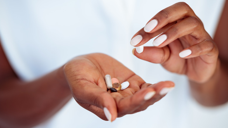 Hand holding various supplements