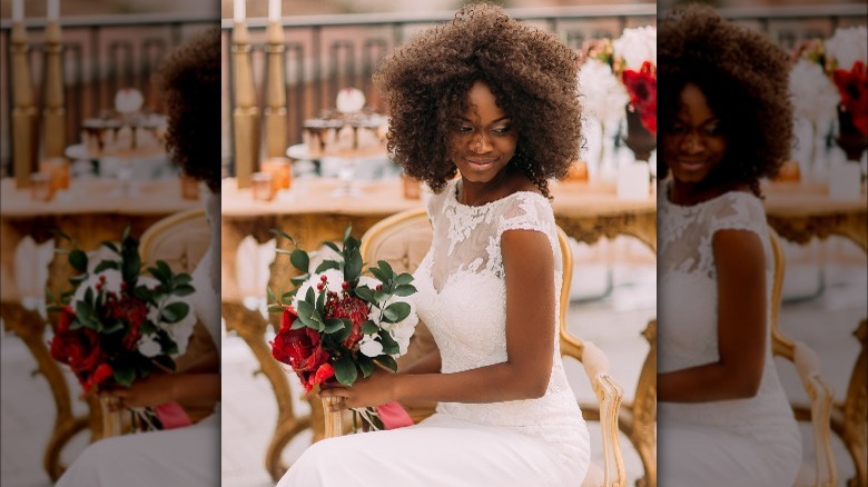 Woman wearing a lace wedding dress and holding a bouquet