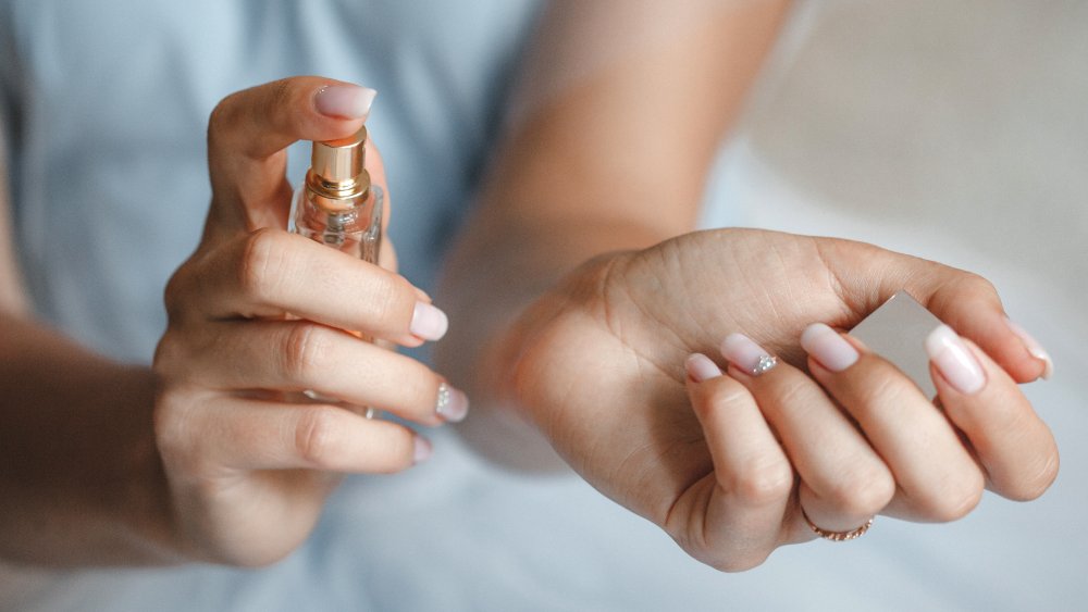 Woman spraying perfume on her wrist