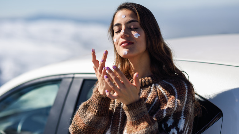 A woman applying sunscreen 