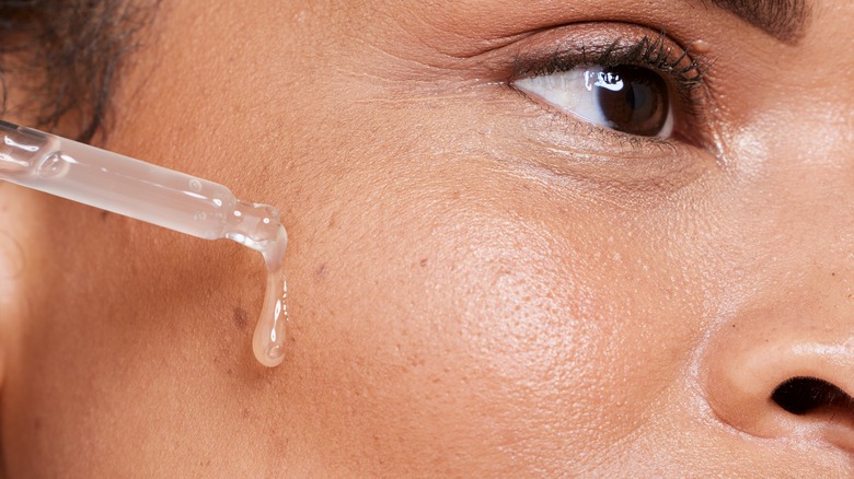 A woman applying a serum