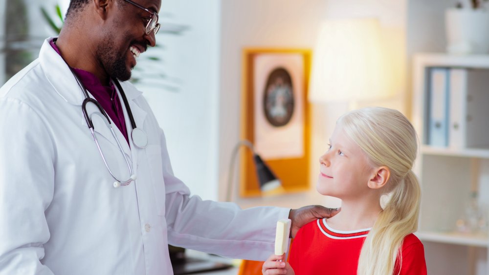 Doctor giving girl ice cream