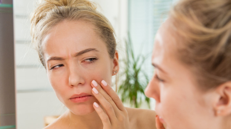 Woman examining her undereye area 