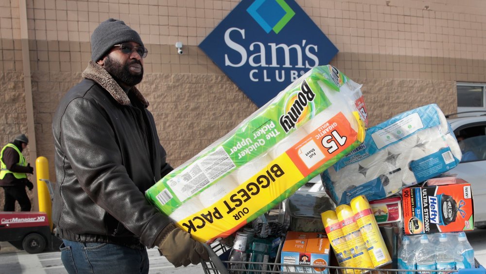 A man with a full shopping cart outside a Sam's Club