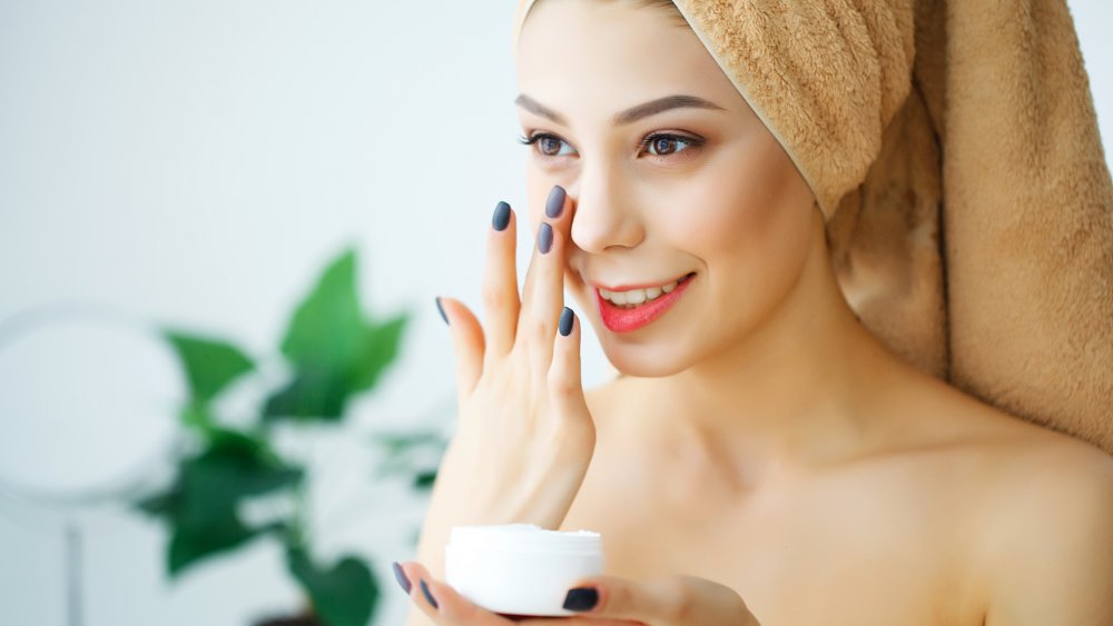 Woman applying moisturizer