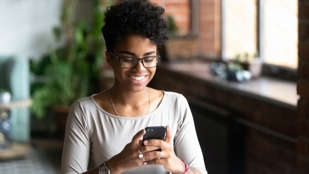 Woman enjoying reading on her phone 