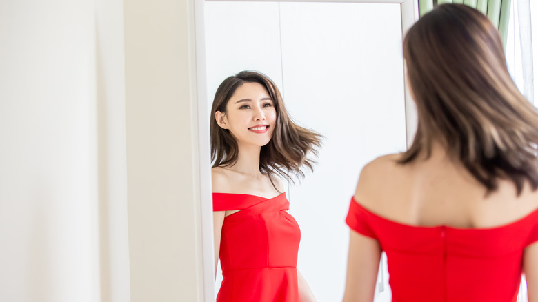 Woman wearing a red dress looking in the mirror