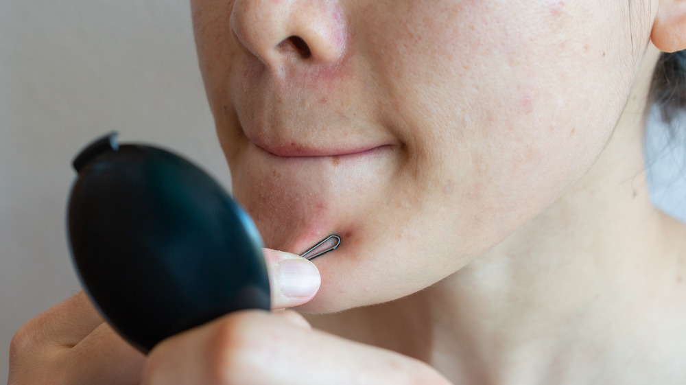 Woman extracting her own pimples