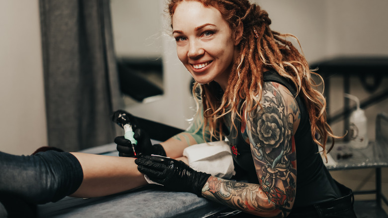 Woman giving a tattoo