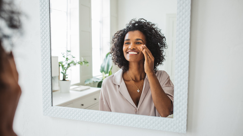 Smiling woman looking in mirror