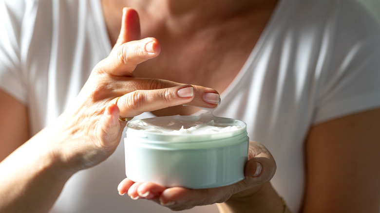 Hands holding moisturizer jar