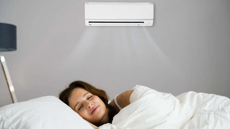 woman sleeping under air conditioning unit