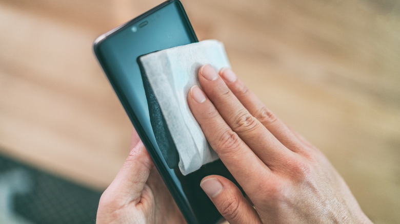 Woman's hands clean cell phone