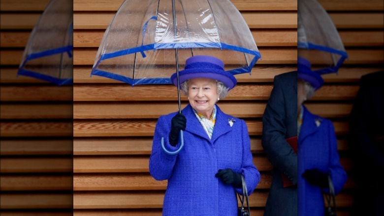 Queen Elizabeth holding blue umbrella