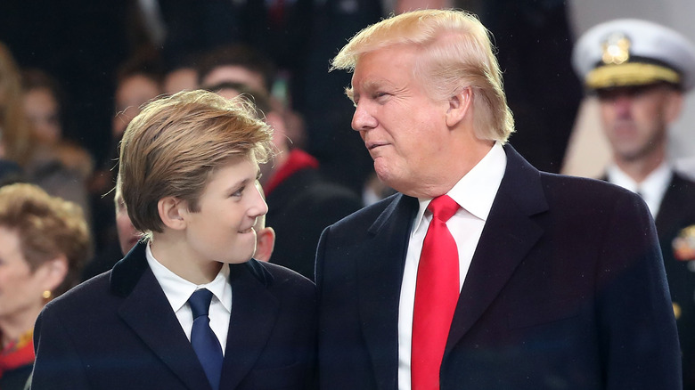 Barron Trump standing next to his father in a suit