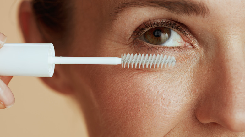 Woman applying eyelash product