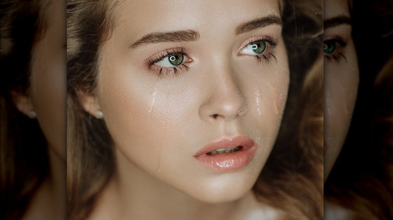 Woman with long eyelashes crying