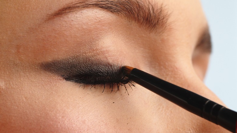 applying eyeshadow with pencil brush