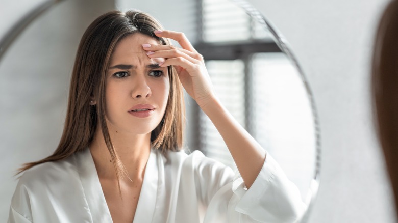 woman frowning in mirror