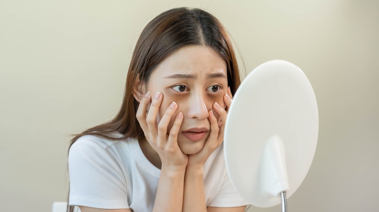 woman looking at herself in mirror