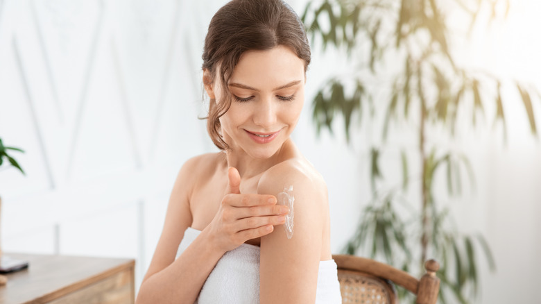 Woman applying moisturizer