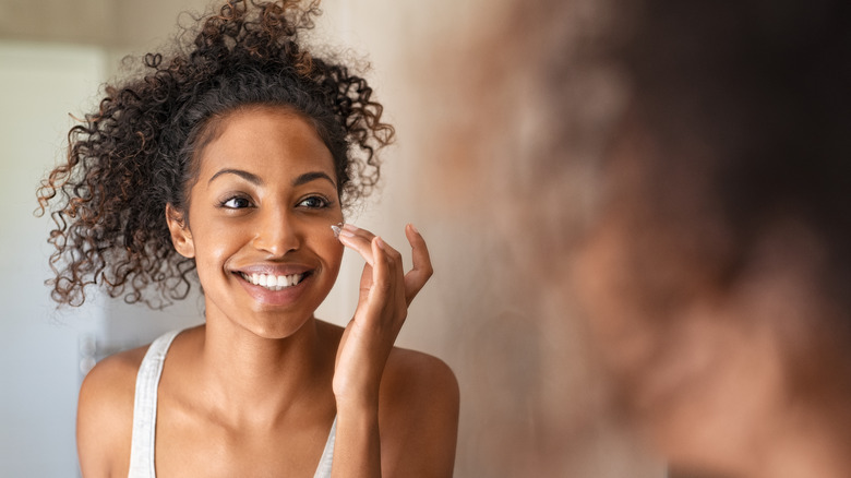 Woman applying moisturizer 