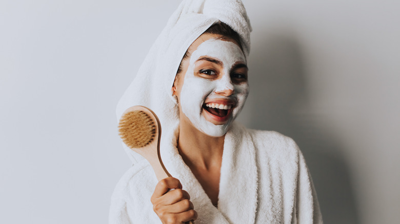 smiling woman with face mask wearing robe