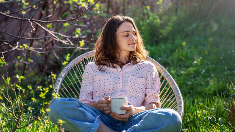 woman sitting in sun with coffee