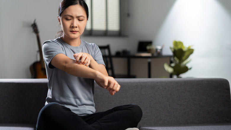 woman scratching arm