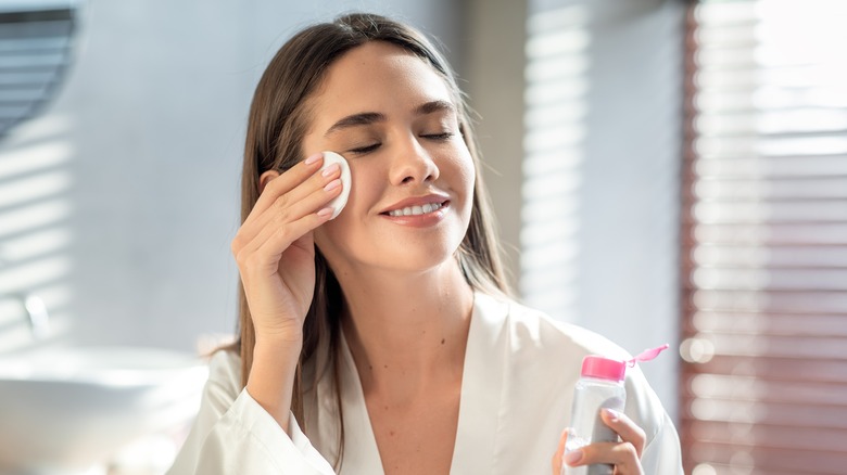 Woman cleansing face smiling