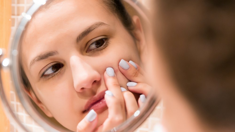 Woman looking at her pimples