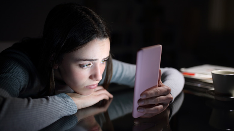 Sad woman looking at phone