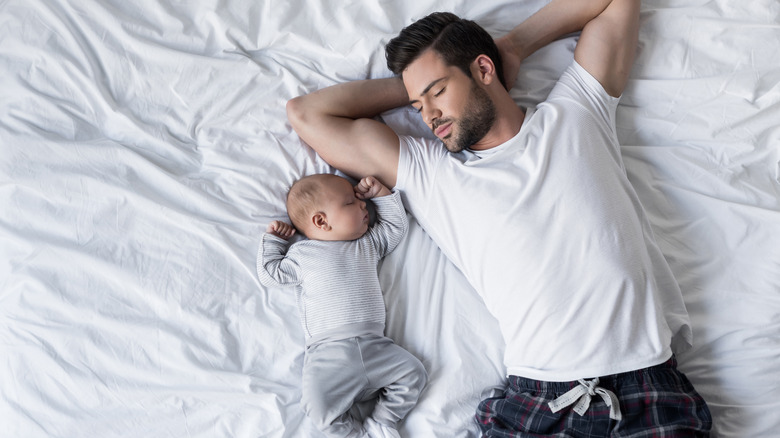 baby and daddy laying in bed