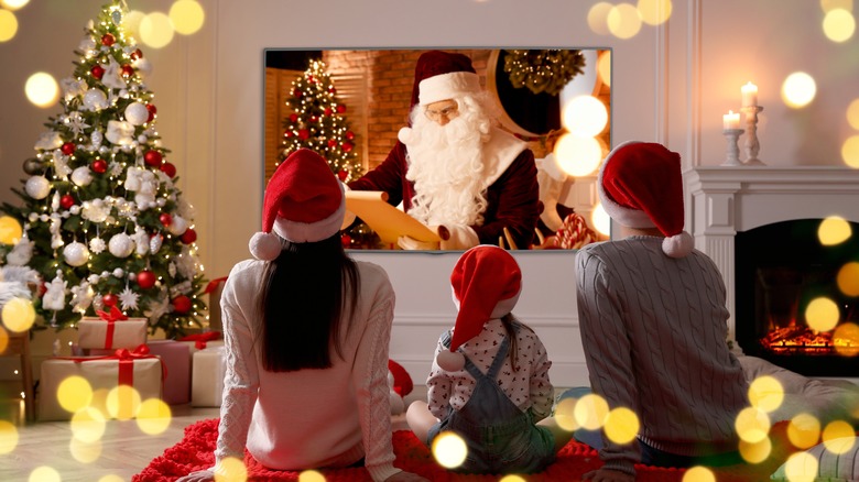 family watching christmas movie in santa hats